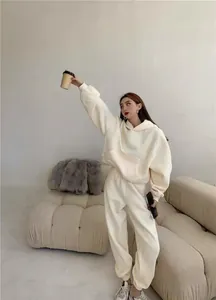Modelo luciendo conjunto de sudadera con capucha y pantalón jogger de forro polar crema