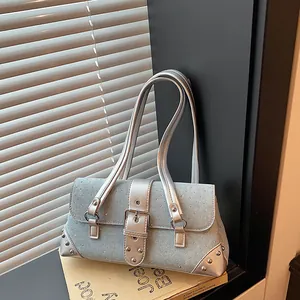 Detail shot of a light blue denim baguette bag with rhinestones and silver straps
