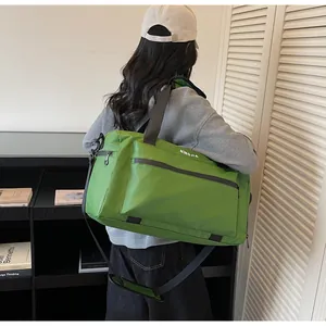 Detail view of a large green travel bag with NINGJIA logo, shown on a model's shoulder.