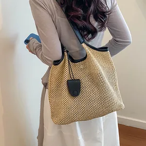 Vista dettagliata di una borsa tote in paglia intrecciata con finiture nere