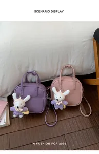 Detailansicht kleiner quadratischer Handtaschen in Lila und Rosa mit süßen Hasenanhängern.