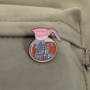 Detail view of coffee pot enamel pin with ambition slogan on backpack