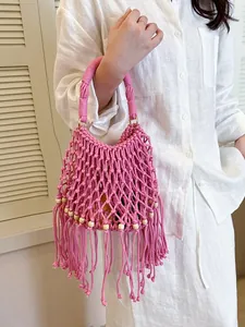 Stylish hand-woven pink macramé bucket bag for summer featuring tassels and beads