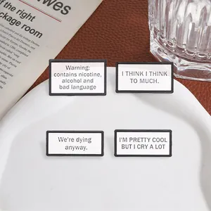Set of four rectangular enamel pins with humorous English quotes on a white plate.