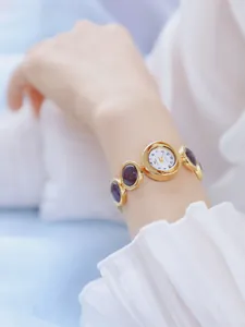 Detalle del elegante reloj de pulsera para mujer con piedras de arena estelar púrpura