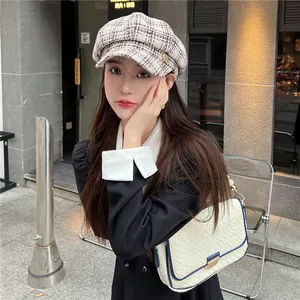 Close-up of a stylish plaid newsboy cap in a chic urban street fashion setting