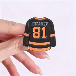 Macro detail of a black and orange hockey jersey enamel pin with Rozanov 81 text