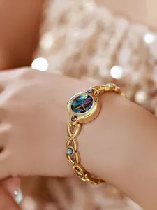 Primer plano de reloj dorado vintage con esfera de nácar en la muñeca femenina