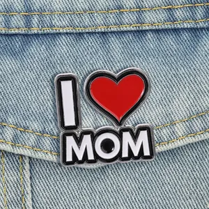 Primer plano de un pin esmaltado de corazón I Love Mom sobre una chaqueta vaquera