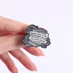 Vue détaillée d'un pin's en émail avec roses, livres et slogan morally grey