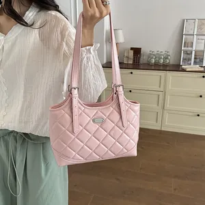 Detailansicht einer rosa gesteppten Tragetasche aus Kunstleder, die getragen wird.