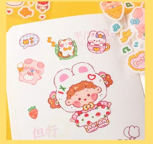 Macro view of cute cartoon animal PVC stickers applied to a white notebook page