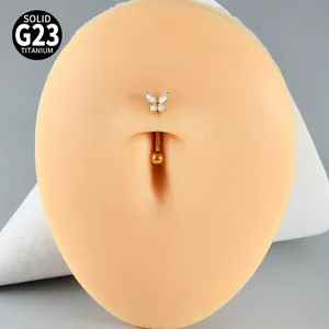 Close-up of golden G23 titanium butterfly navel ring with sparkling white zircons.