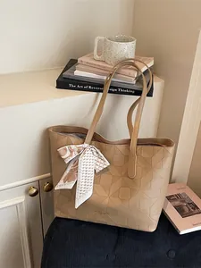 Stylish khaki tote bag with geometric embossed pattern and decorative silk scarf