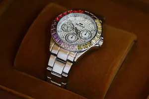 Close-up of luxury women's watch featuring a rainbow crystal bezel and iced-out dial