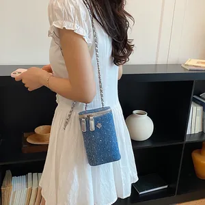 Detailed view of the blue denim chain crossbody cell phone bag with rhinestone accents