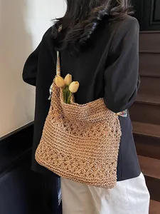 Sac cabas chic en paille tressée avec motif floral ajouré et bandoulière colorée.