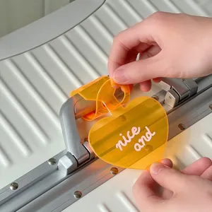 Premium transparent orange heart luggage tag with 'nice and' text on white suitcase