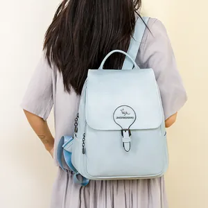 Vue de dos d'une femme portant un grand sac à dos de voyage décontracté bleu clair