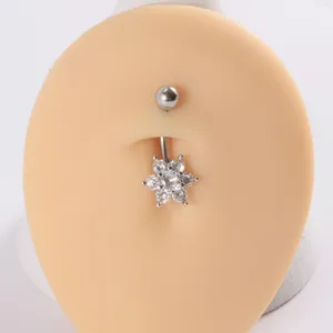 Primer plano de un piercing para el ombligo en forma de flor con circonitas brillantes