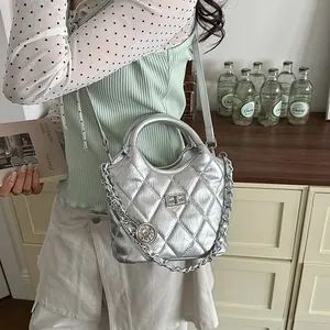 Elegant silver metallic quilted shoulder bag shown in a stylish lifestyle setting.