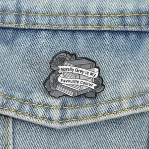 Vue détaillée de l'épingle en émail rose grise et livres sur une poche de jean bleu