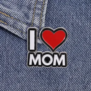 Primer plano de un broche esmaltado 'I Love Mom' sobre tela denim azul.