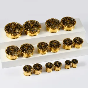 Gedetailleerd macro-overzicht van vintage gouden vleermuis-oorplugs in diverse maten op stand