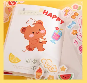 Close-up view of various cute cartoon PVC waterproof stickers applied to a grid notebook