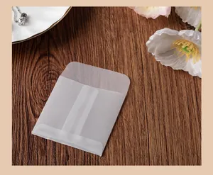 Detailed view of small translucent vellum envelope on a natural wood grain surface
