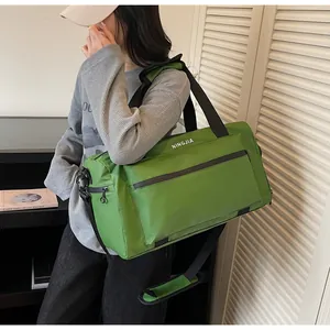 Large green travel duffel bag shown on a model, ideal for gym or short weekend trips.
