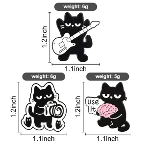 Detailed view of three black cat enamel pins with guitar and camera showing dimensions