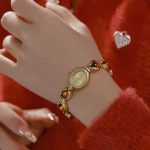 Vista detallada de un reloj de pulsera dorado vintage con piedras de ojo de tigre.