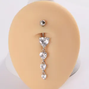 Primer plano de un piercing en el ombligo con circonitas de corazón