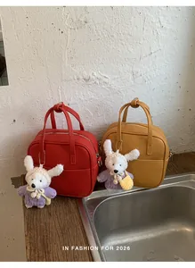 Detailansicht der roten und gelben Mini-Vierecktaschen aus Leder mit Hasenanhängern