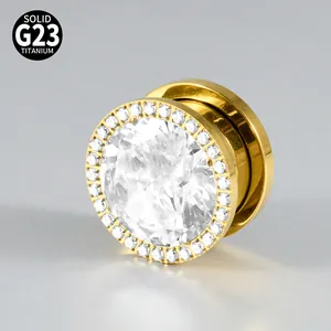 Macro view of G23 titanium ear gauge with gold finish and sparkling zirconia stones