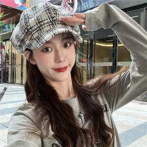 Detailed view of a woman wearing a stylish plaid newsboy cap in a classic winter style.