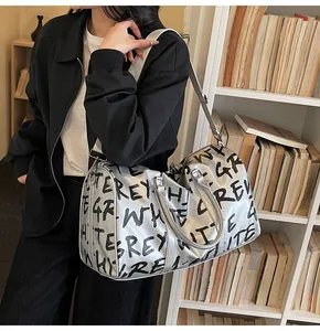 Large graffiti letter travel bag for women, showing model carrying style in library