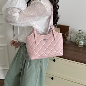 Detaillierte Lifestyle-Ansicht einer stilvollen rosa gesteppten Tragetasche an der Schulter.