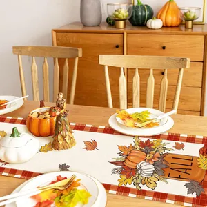 Elegante runner da tavola autunnale con zucche e foglie d'acero su tavolo in legno