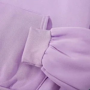 Détail en gros plan des poignets côtelés d'un sweat à capuche en polaire violet lavande