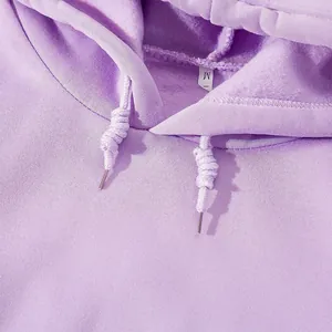 Détail d'un sweat à capuche violet doublé de polaire avec cordon de serrage au col.