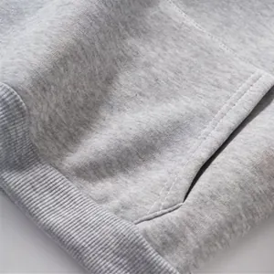 Détail macro du tissu polaire chiné gris pour sweat à capuche avec coutures d'ourlet
