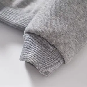 Détail rapproché du poignet côtelé d'un sweat en polaire grise et texture du tissu
