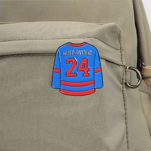 Detailed view of a blue and red hockey jersey enamel pin on a green backpack