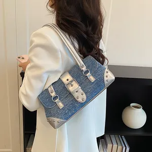 Detail showing the denim baguette bag with silver accents and studs on model's shoulder.