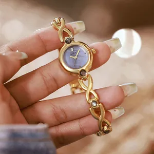 Primer plano de un reloj vintage dorado con esfera de nácar en color lavanda