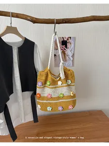 Vue détaillée d'un grand sac cabas au crochet fait main avec des fleurs 3D colorées.