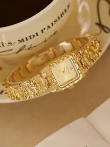 Primer plano de reloj de pulsera vintage dorado con textura de lava y esfera
