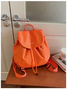 Detail view of a vibrant orange checkered backpack for women, ideal for casual and daily use.